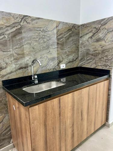 a bathroom sink with a black counter top at GM Suites in Cúcuta