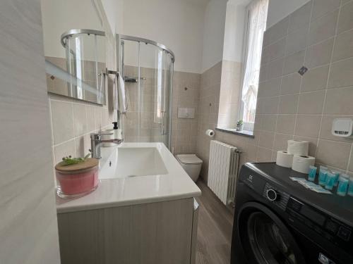 a bathroom with a sink and a washing machine at Sweet Home - Wi-fi Gratuito in Monza