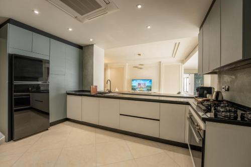 a kitchen with white cabinets and black counter tops at World Heart Residences in Baghdad