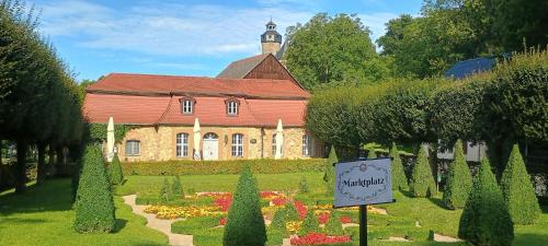 a building with a garden and a sign in front of it at Ferienwohnung Ohne Gleichen 