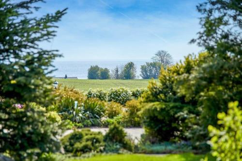 a garden with a view of a field and the ocean at 30580-Odder-Grindsnabevej-31 in Odder
