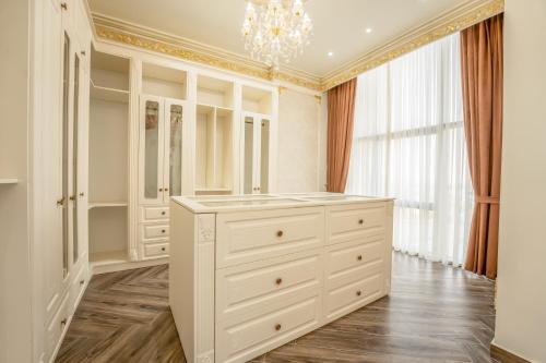 a dressing room with a white dresser and a chandelier at World Heart Residences in Baghdad