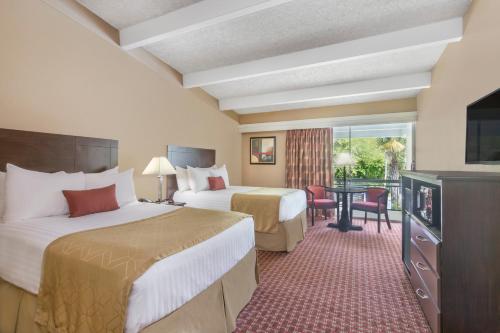 a hotel room with two beds and a television at Travelodge by Wyndham Lakeland in Lakeland