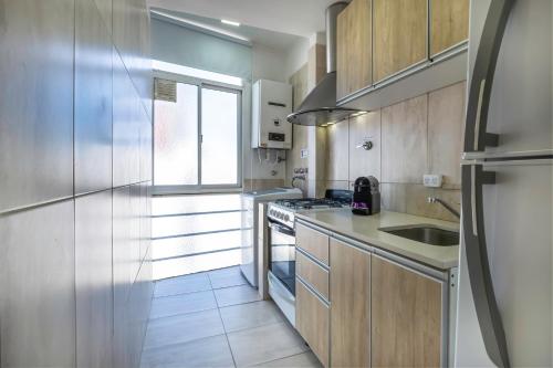 a small kitchen with a sink and a stove at Moderno piso 10! Garage! River - ViaVivaChino in Buenos Aires