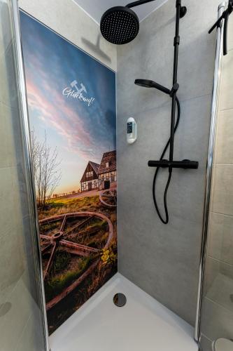 a shower stall with a painting of a farm at Pension Krone in Freiberg