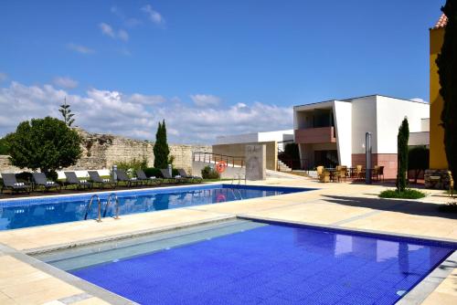 a large swimming pool in front of a building at Pousada Convento de Tavira in Tavira