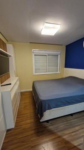 Un dormitorio pequeño con una cama y una ventana. en Amplo Apartamento 1 D com VAGA, en Porto Alegre