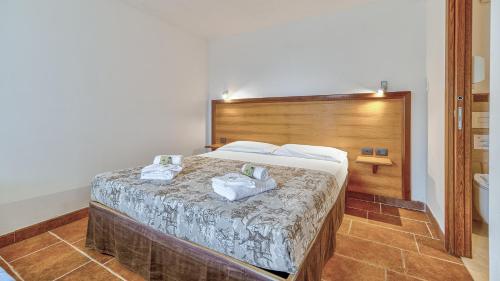 a bedroom with a bed with two towels on it at Tenuta dell'Argento Pool&Relax by Rentbeat in Civitavecchia