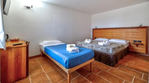 a bedroom with two beds and a table with towels at Tenuta dell'Argento Pool&Relax by Rentbeat in Civitavecchia