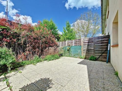 a backyard with a fence and a sidewalk at Un calme à la ville in Darnétal