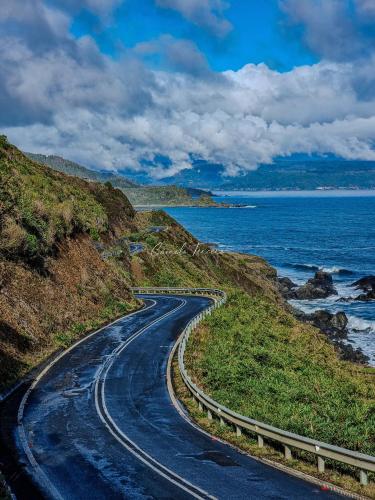 a winding road on a hill next to the ocean at Refugio de montaña con vista al mar in Curiñanco