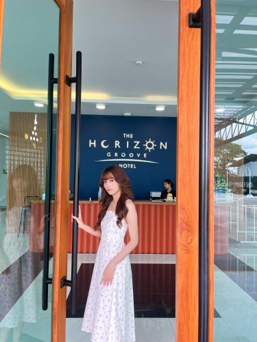 a woman standing in front of a revolving door at The Horizon Groove Hotel in Ban Khlong