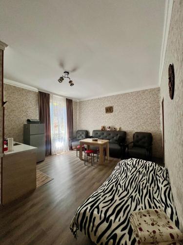 a bedroom with a zebra print bed and a living room at Achela's Guesthouse in Borjomi