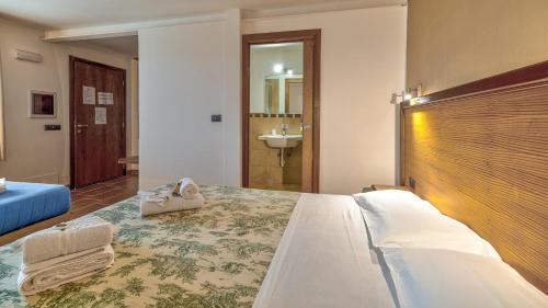 a hotel room with a bed and a sink at Tenuta dell'Argento Pool&Relax by Rentbeat in Civitavecchia