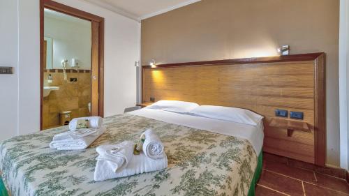 a hotel room with a large bed with towels on it at Tenuta dell'Argento Pool&Relax by Rentbeat in Civitavecchia