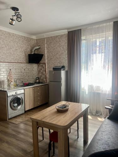 a kitchen with a table and a kitchen with a refrigerator at Achela's Guesthouse in Borjomi