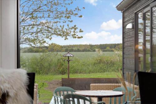 a patio with a table and chairs and a view of a field at 30458-Odder-Strandvaenget-44 in Odder