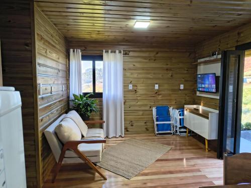 a living room with wooden walls and a tv and a couch at Chalet in Bom Princípio in Bom Princípio