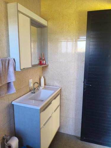 a bathroom with a sink and a mirror and a shower at Chalet in Bom Princípio in Bom Princípio