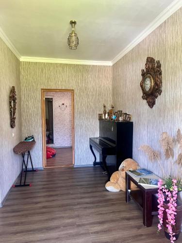a living room with a piano and a stuffed animal at Achela's Guesthouse in Borjomi