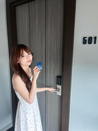 a woman holding a credit card in a hotel room at The Horizon Groove Hotel in Ban Khlong