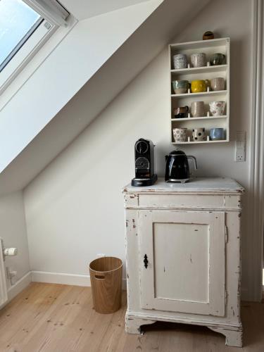a room with a white cabinet under the stairs at Digebjerggaard Bed & Breakfast in Vester-Skerninge