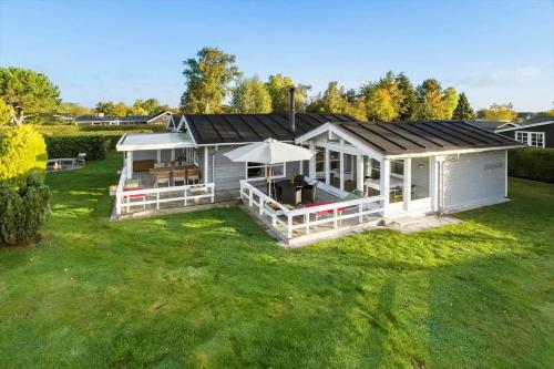 a white shed with a roof on a yard at 30516-Odder-Birkevaenget-7 in Odder