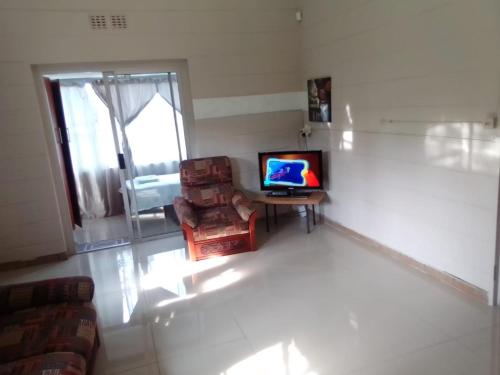 a living room with a television and a chair at Unit51 MarinaGlen Holiday Resort in Marina Beach