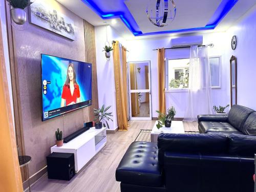 a living room with a couch and a flat screen tv at Belle Villa Appartement avec Gardien in Mbaw Gou Ndaw