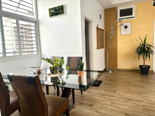a dining room with a glass table and chairs at Belle Villa Appartement avec Gardien in Mbaw Gou Ndaw