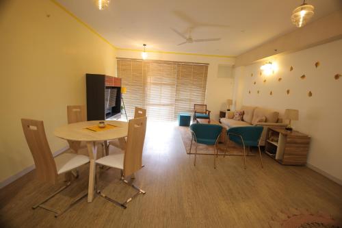 a living room with a table and chairs and a couch at Better Life Homes - For active seniors above 50 years in Barog