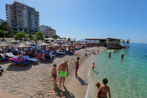 a beach with a crowd of people in the water at Sunset Aparthotel in Sarandë