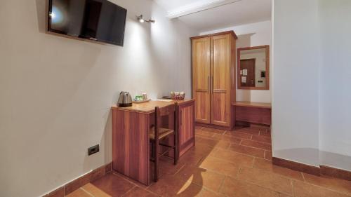 a room with a desk and a television on a wall at Tenuta dell'Argento Pool&Relax by Rentbeat in Civitavecchia