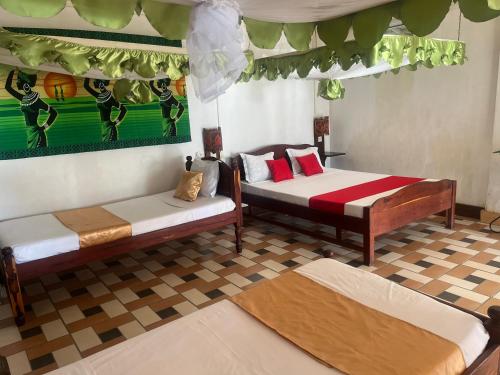 a room with two beds and a painting on the wall at Villa Maroloko in Ifaty