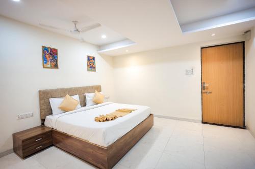 a bedroom with a bed and a wooden door at SoonStay Hotel Konark in Indore