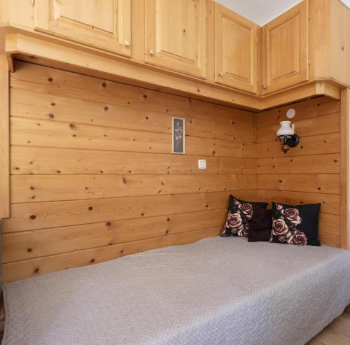 a bed in a room with a wooden wall at Gästehaus Kerber in Steeg
