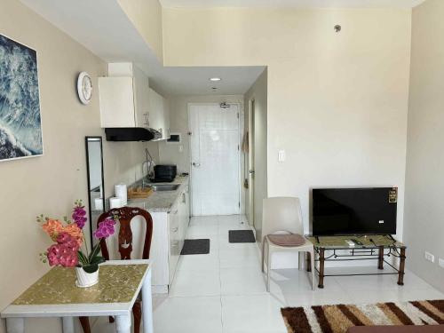 a kitchen and living room with a table and a television at Sunvida Tower staycation unit 2503-2504 in Cebu City