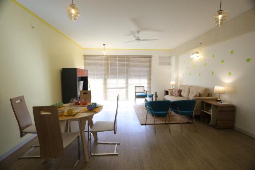 a living room with a couch and a table and chairs at Better Life Homes - For active seniors above 50 years in Barog