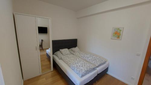 Ferienwohnungen am Büchlhof im Oberpfälzer Seenland في نينبورغ فورم والد: غرفة نوم صغيرة مع سرير ومرآة