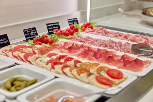 a buffet with many different types of meats and vegetables at Hotel Castello Lake Front in Malcesine