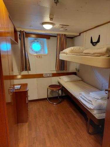 a small room with two bunk beds and a window at Laivahostel S/S Bore in Turku