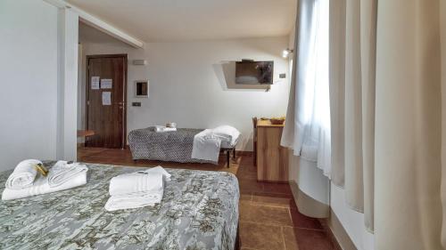 a hotel room with a bed and a bedroom at Tenuta dell'Argento Pool&Relax by Rentbeat in Civitavecchia