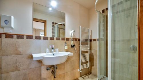 a bathroom with a sink and a shower at Tenuta dell'Argento Pool&Relax by Rentbeat in Civitavecchia