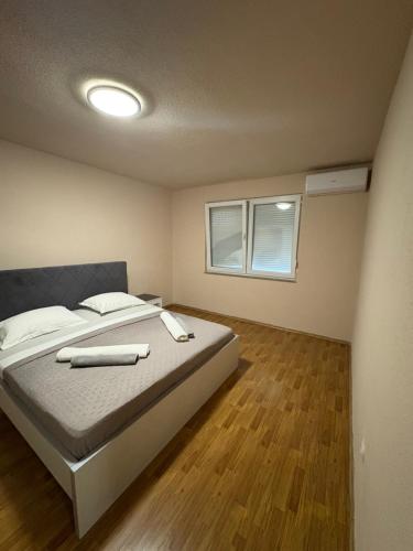 a bedroom with a large bed with a wooden floor at La casa Mia in Posušje
