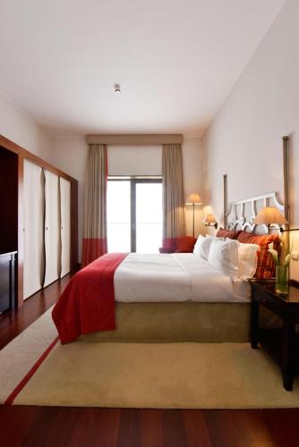a large bedroom with a large bed and a window at Pousada Convento de Tavira in Tavira