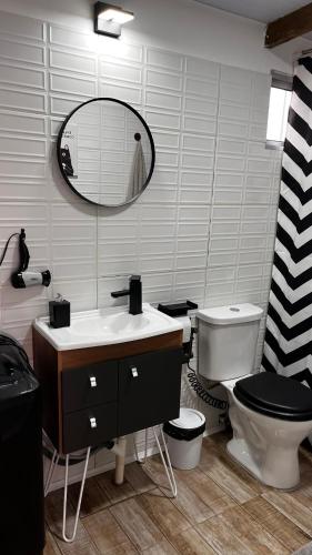 a bathroom with a toilet and a sink and a mirror at Rincon de los Michis in Barra del Chuy