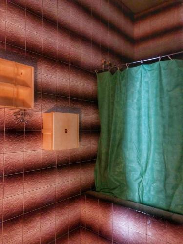 a wall with a green curtain in a room at Siboshvilis Guesthouse in Sagarejo