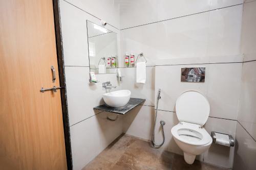 a bathroom with a toilet and a sink at SoonStay Hotel Konark in Indore