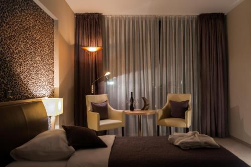 a hotel room with a bed and two chairs at ZOO hotel in Osijek