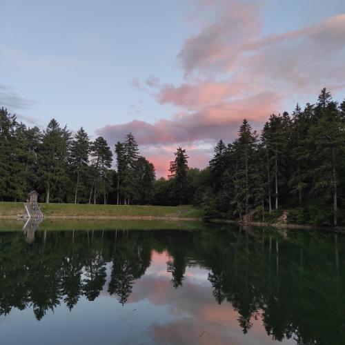a view of a lake at sunset with trees at Chata pri 7 jazerách s vyvýšenou terasou in Štiavnické Bane